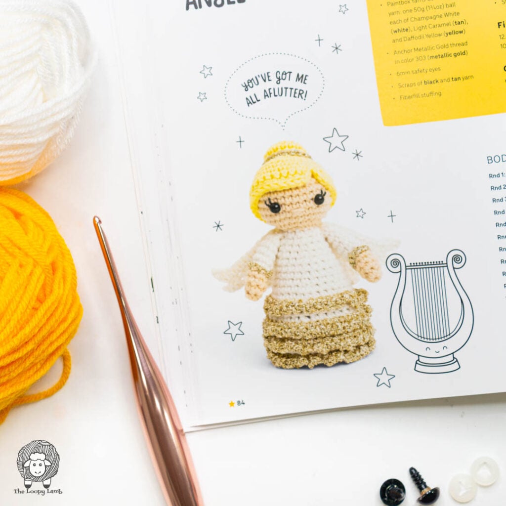 amigurumi angel page from Kawaii Crochet Christmas  show in a flat lay with yarn and a crochet hook.