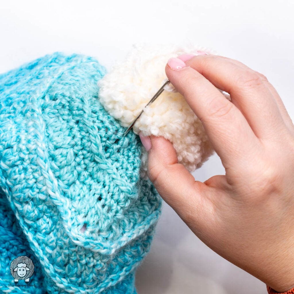 needle is inserted back to the inside of the hat