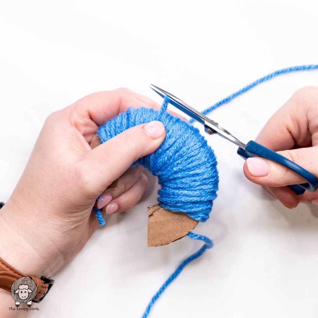 scissors cutting the owrking yarn while one hand holds the warpped yarn secure