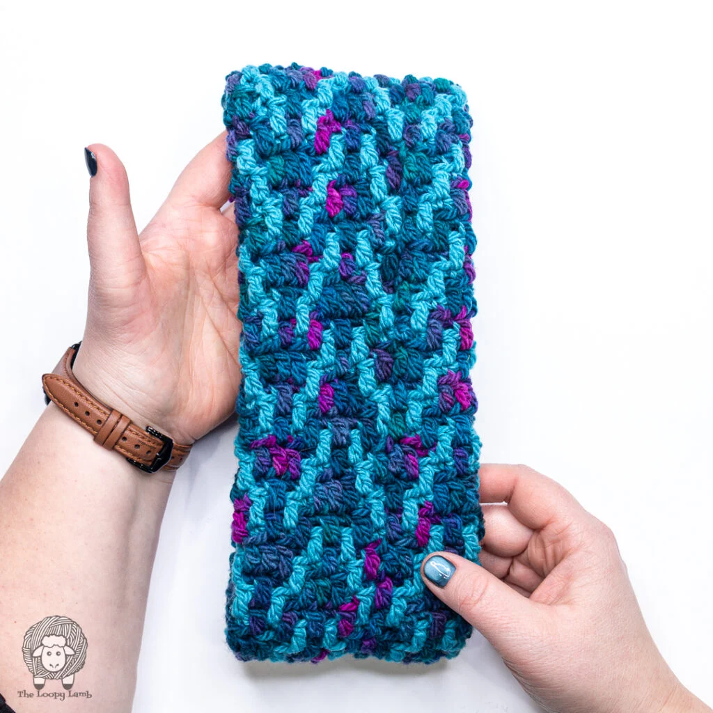 hands holding an overlay mosaic ear warmer to show the colorwork design