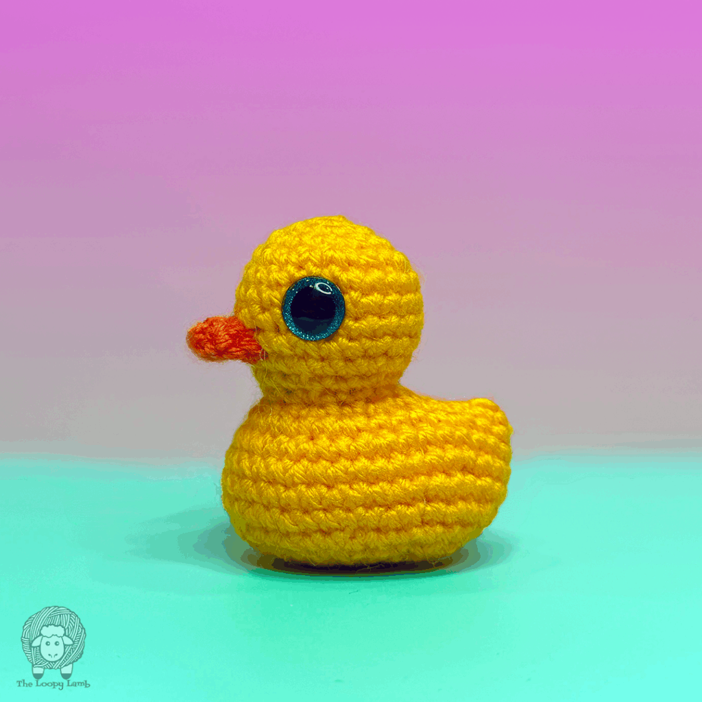 crochet duck on a teal and purple background