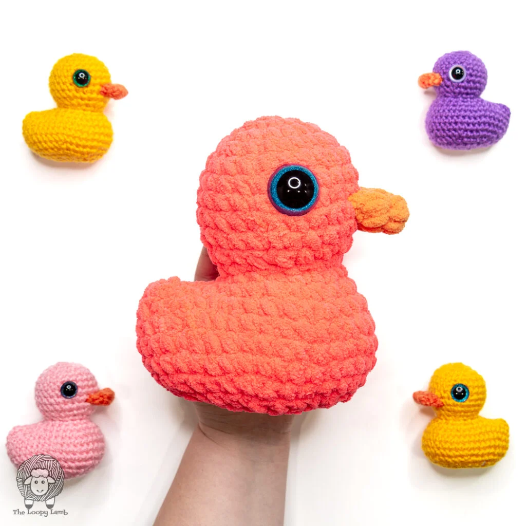 group of 5 crochet rubber ducks in a flat lay on a white background.