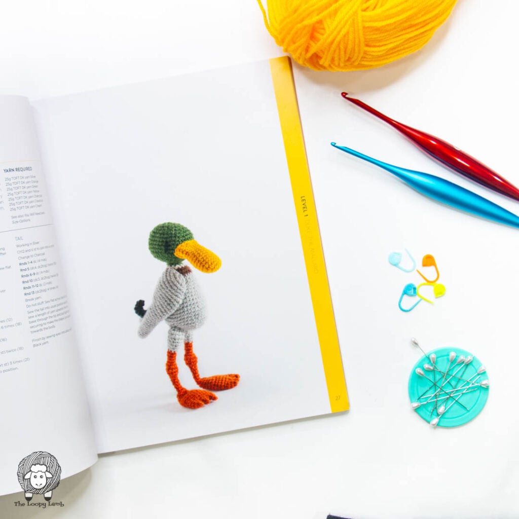 Duke the mallard page open in a flat lay with crochet hooks and yarn