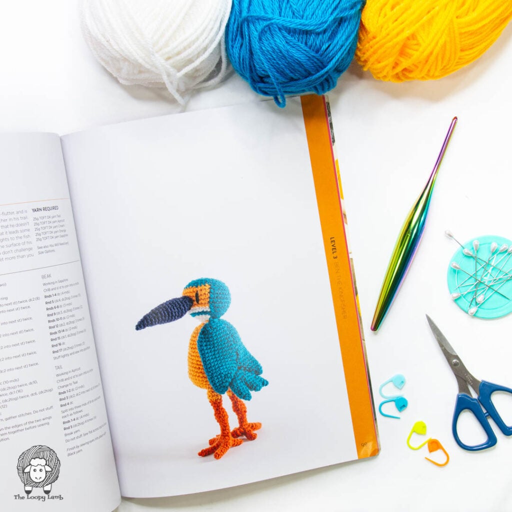 Ben the Kingfisher page open in a flat lay with crochet hook, scissors and stitch markers