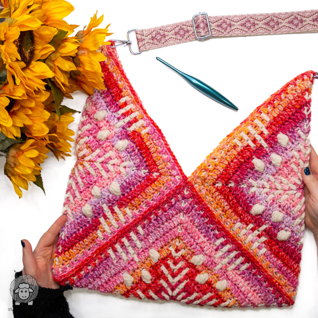 completed crochet granny square bag on a white background