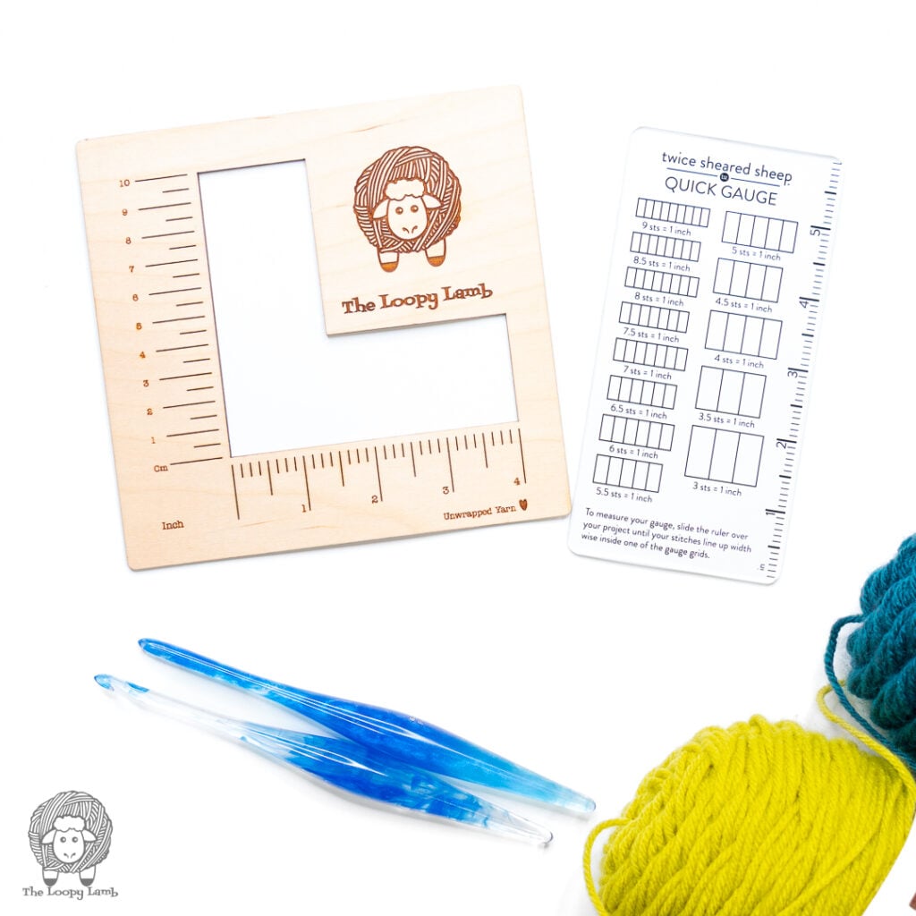 two different gauge rules on a white background next to some crochet hooks and yarn