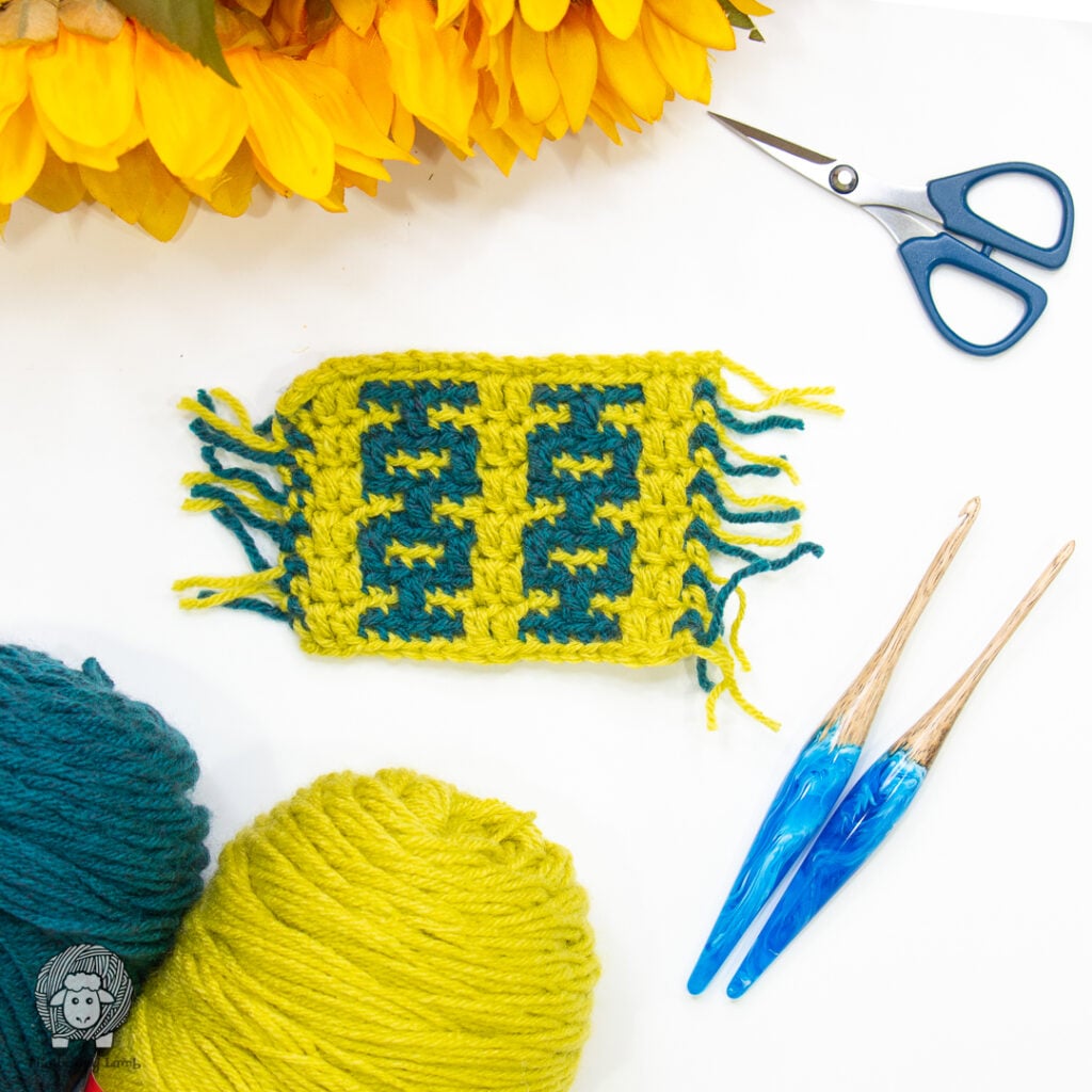 overlay mosaic crochet swatch next to some crochet hooks