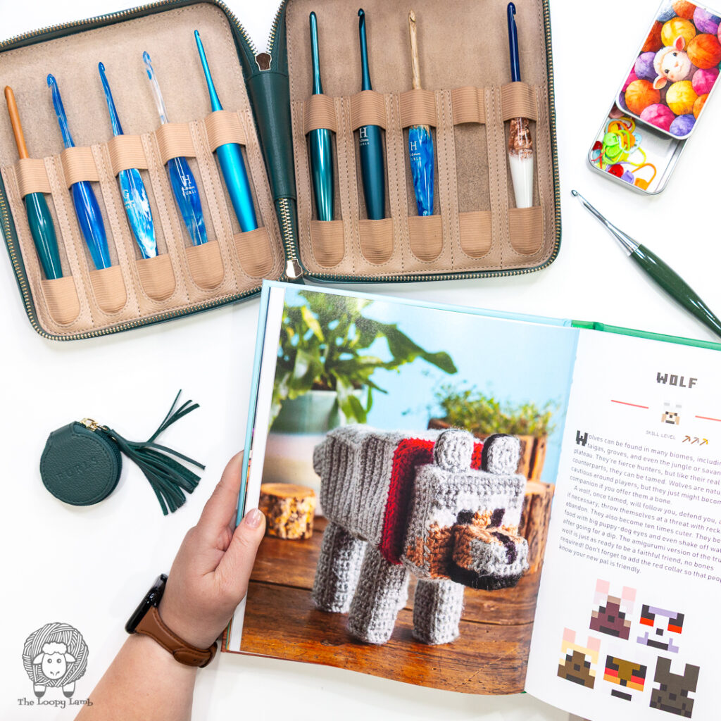 crochet minecraft wolf page open next to furls crochet hooks